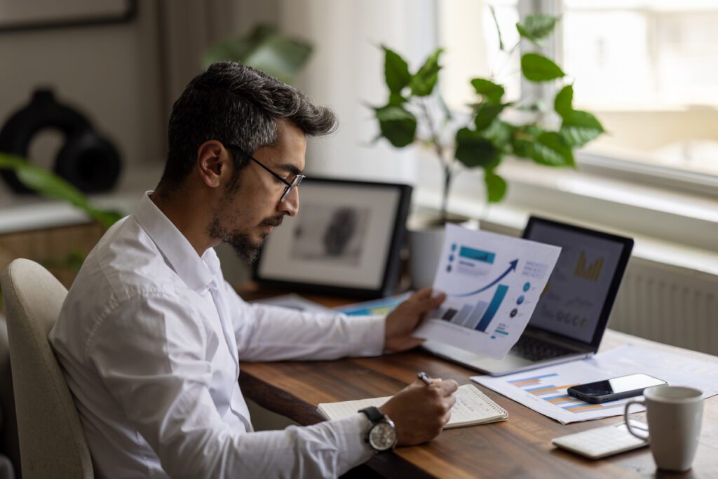 Travel agent analyzing financial reports and charts using accounting software on a laptop